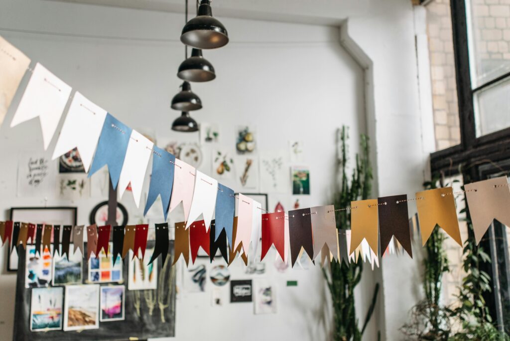 A modern creative studio decorated with vibrant bunting and artwork for an inspiring workspace atmosphere.